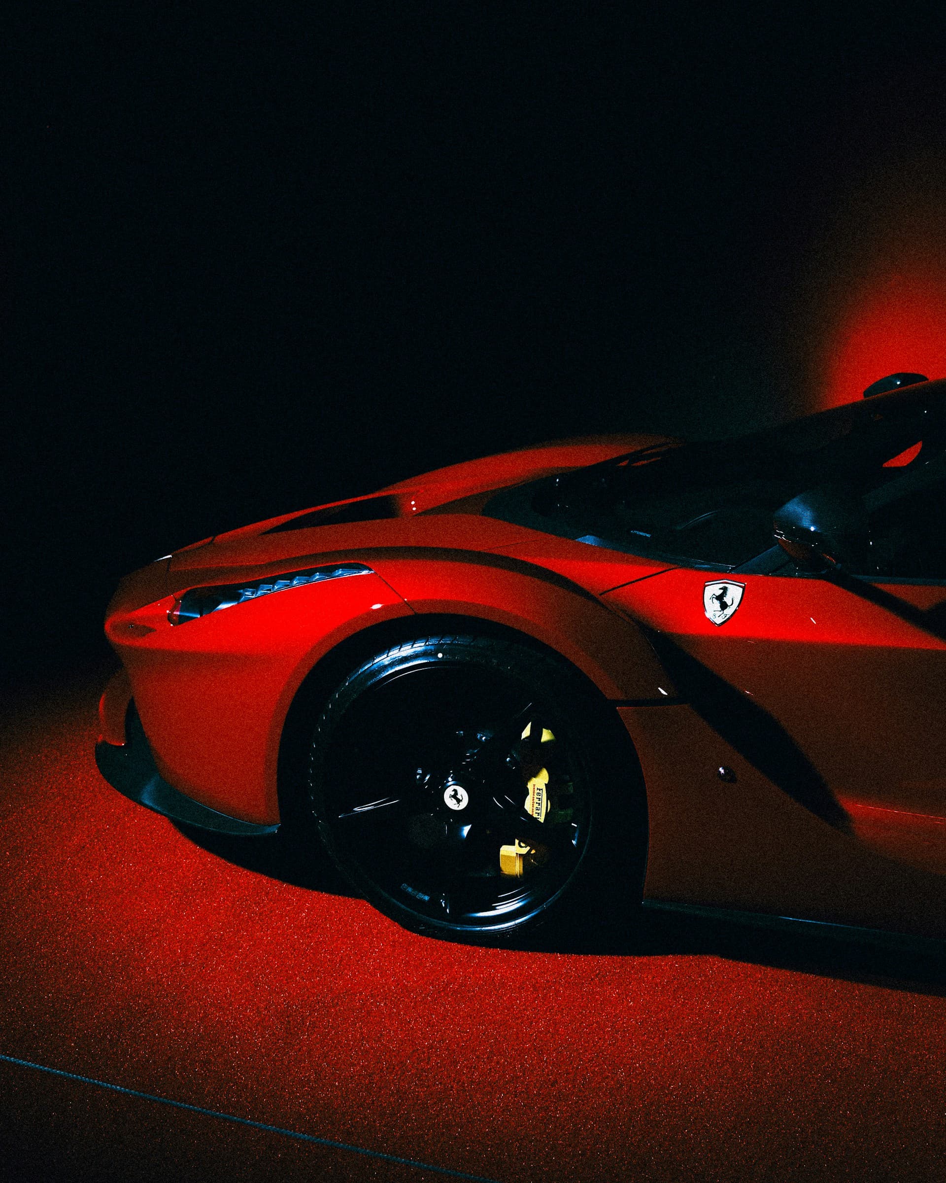 Red Ferrari LaFerrari under dramatic lighting with a deep, glossy finish