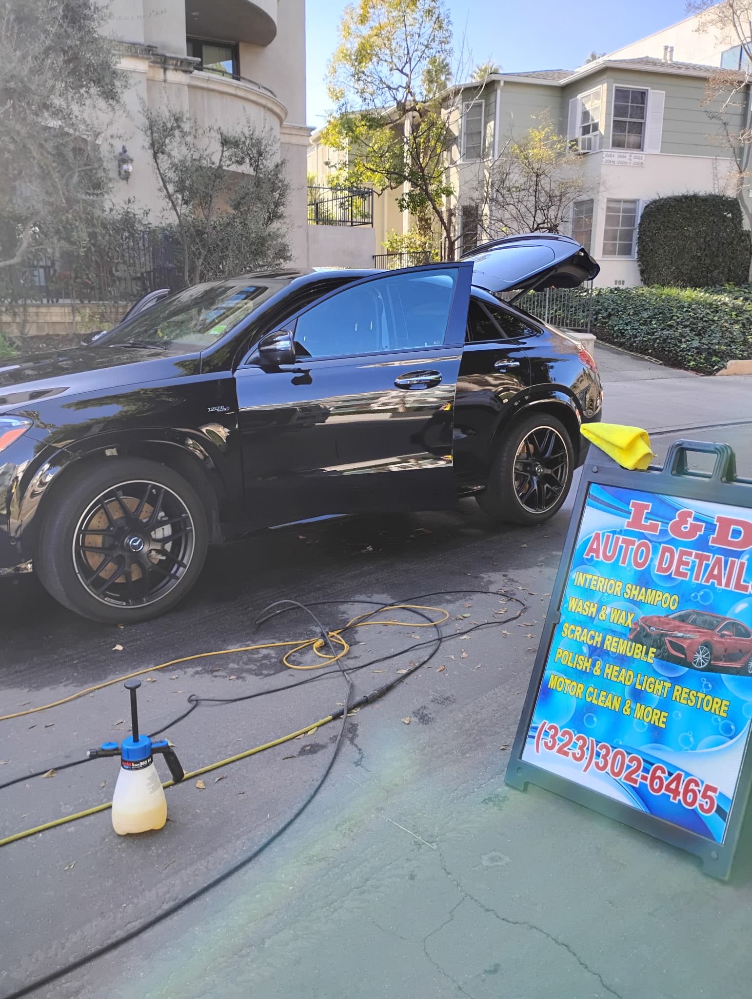 A glossy black Mercedes detailed on-site in a Los Angeles driveway